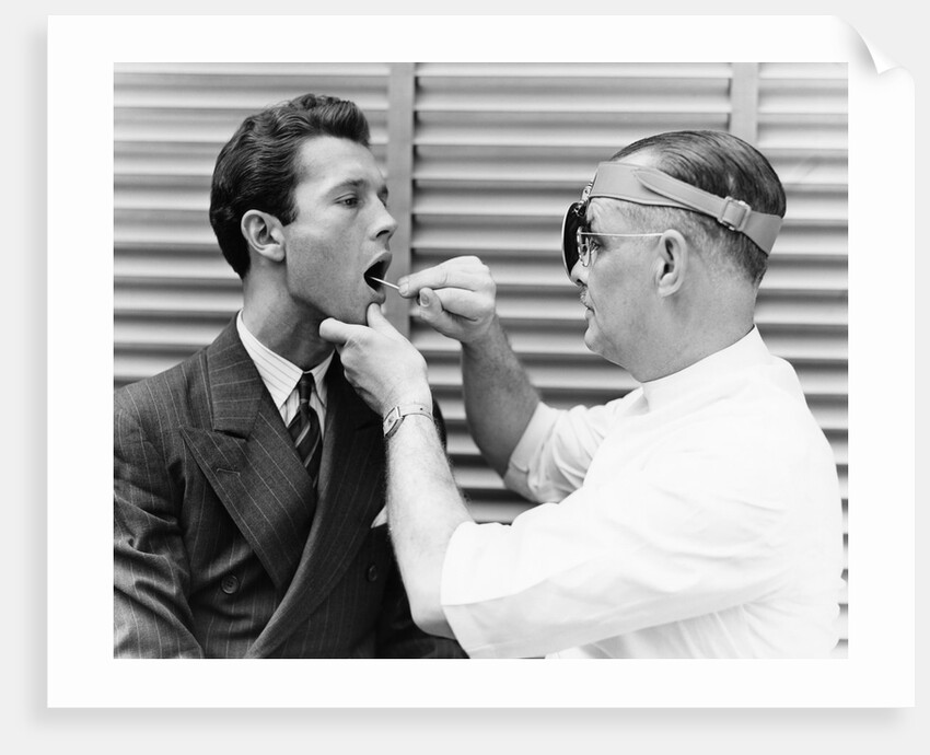 1930s 1940s doctor examining throat of a young man by Anonymous