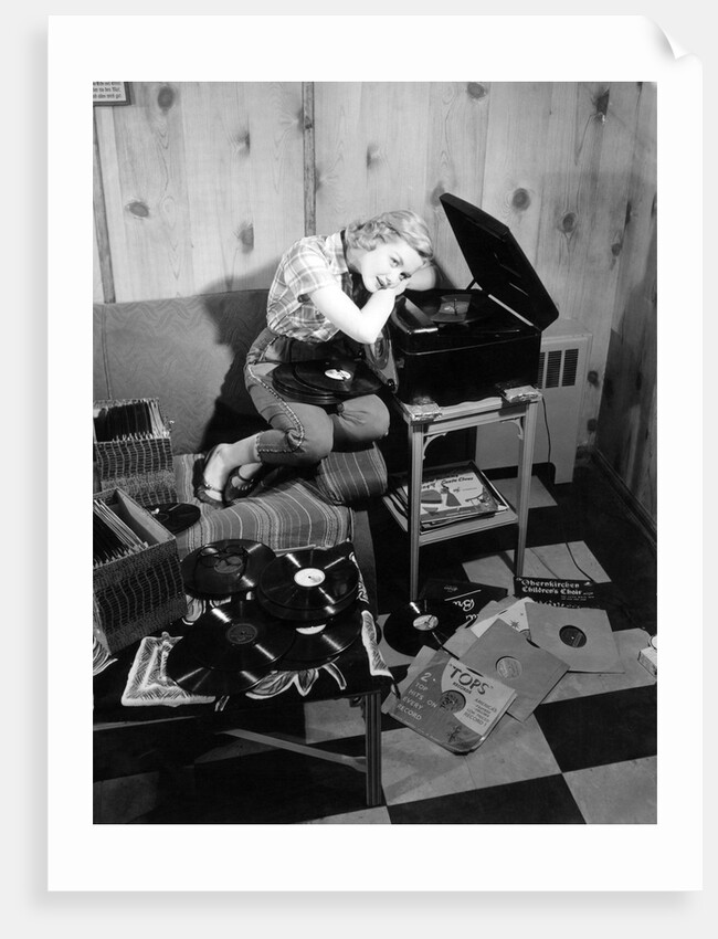 1950s teenage girl listening to music on a phonograph by Anonymous