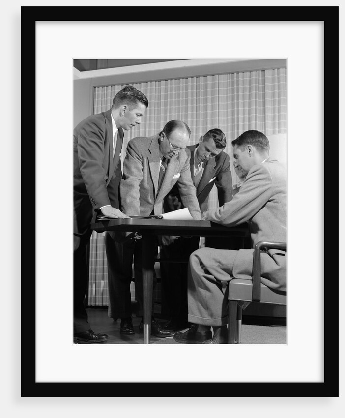 1950s group of businessmen looking at a blueprint on a table by Anonymous