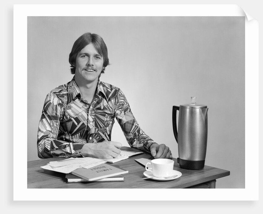 1970s smiling young man working on a budget by Anonymous