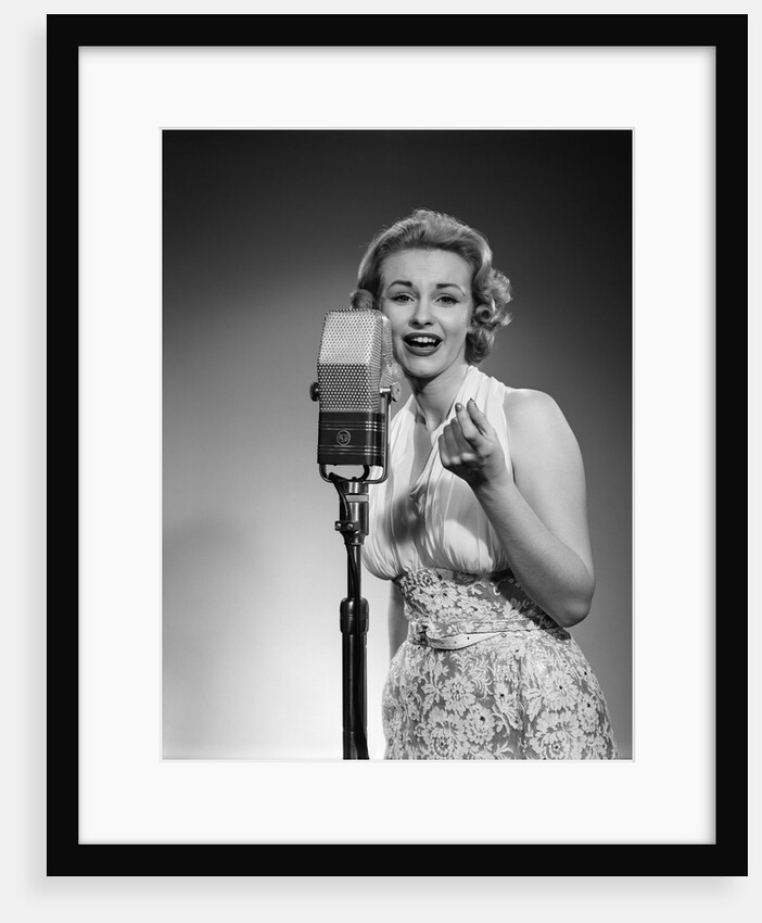 1950s portrait of woman singing into a microphone by Anonymous