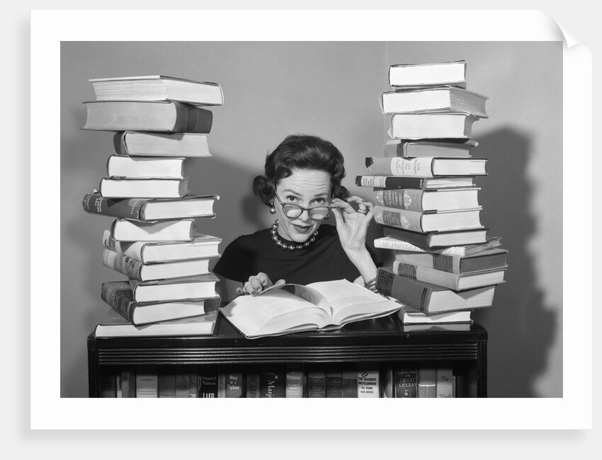 1950s portrait of woman sitting with stacks of books by Anonymous