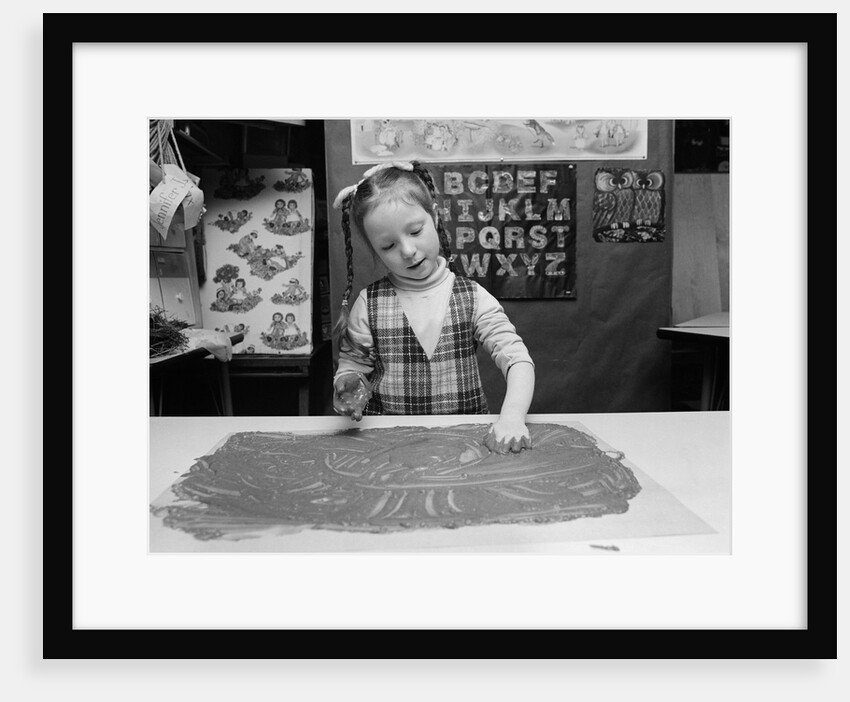 1980s girl with braids finger painting inside a classroom by Anonymous