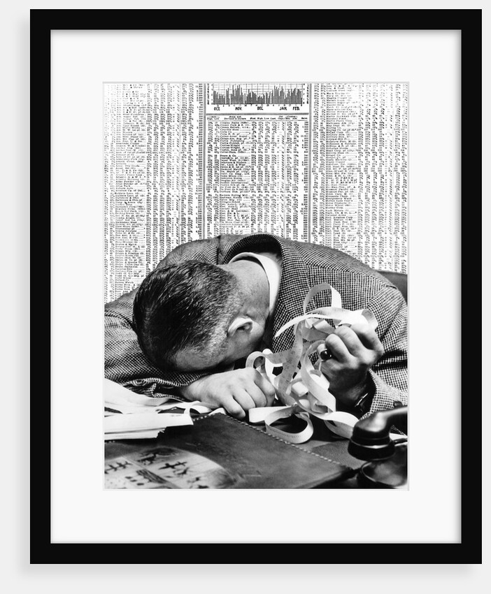 1930s man with head on his desk holding stock ticker tape by Anonymous