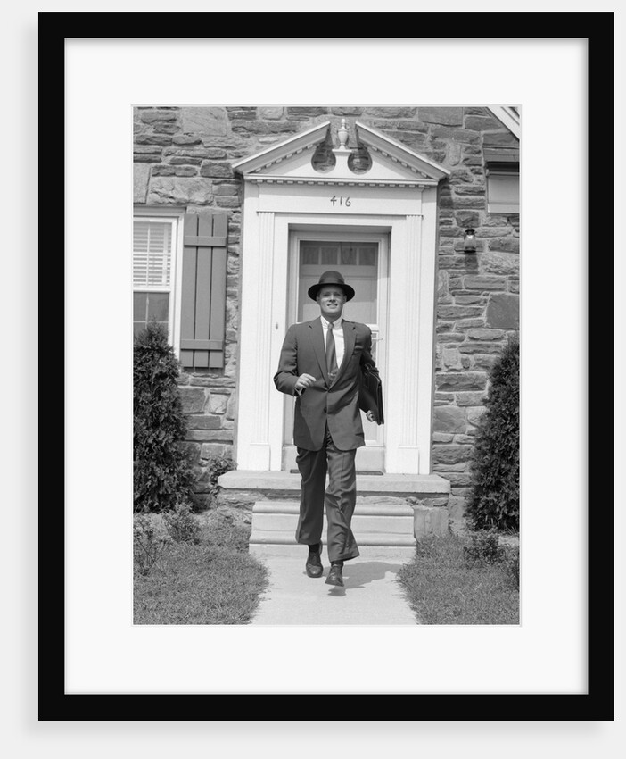 1950s smiling businessman walking out the front door of his house by Anonymous