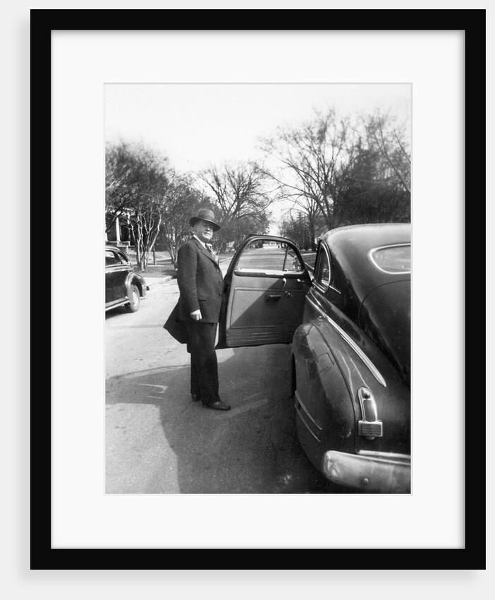 Mature man open his car door, ca. 1940. by Anonymous