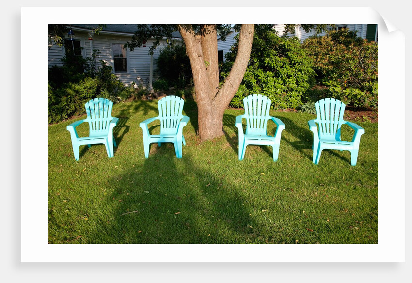 Turquois lawn chairs and green grass at sunset by Anonymous