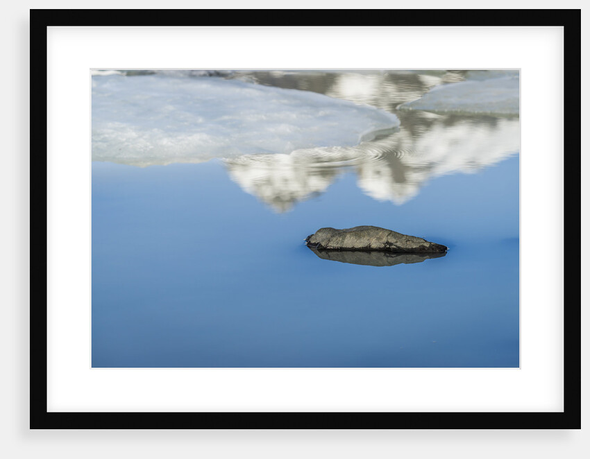 Rock with sky reflected in water. by Anonymous