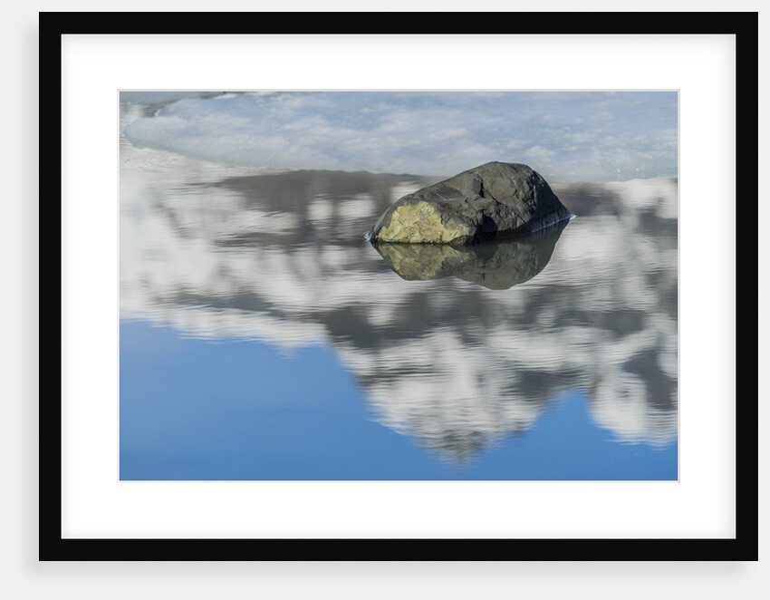 Rock with sky reflected in water. by Anonymous