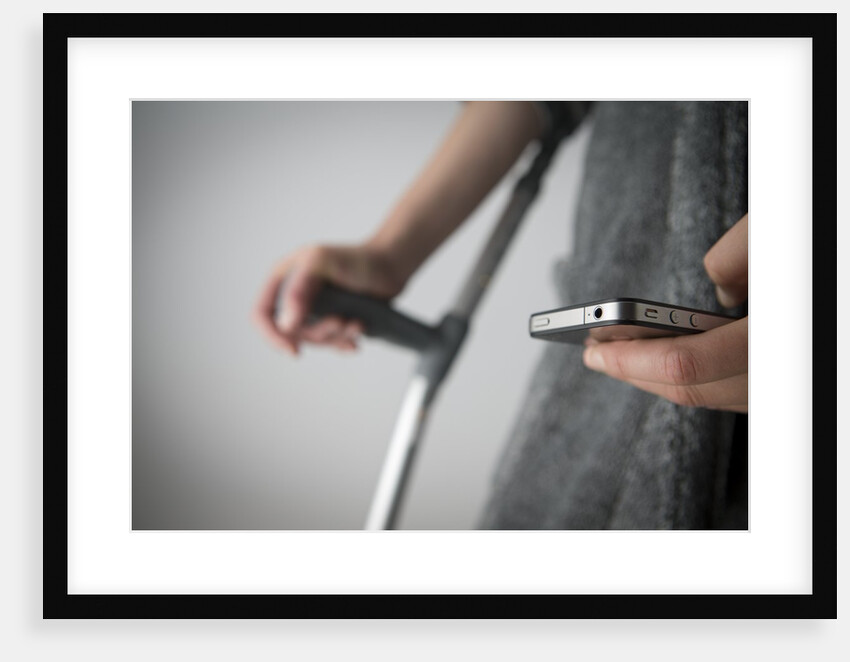 Person on crutches texting by Anonymous