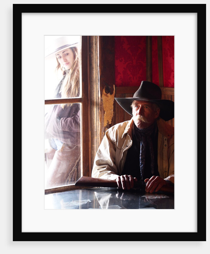 Cowboy with rifle and Cowgirl looking over his shoulder by Anonymous