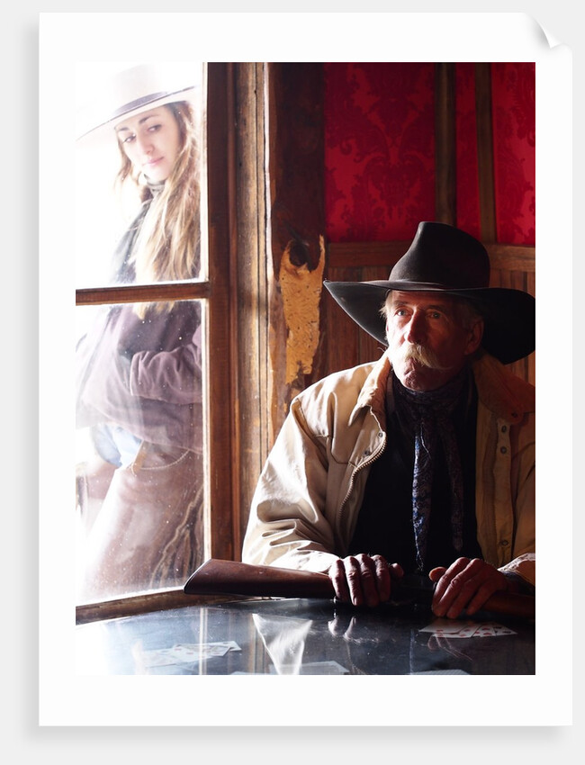 Cowboy with rifle and Cowgirl looking over his shoulder by Anonymous