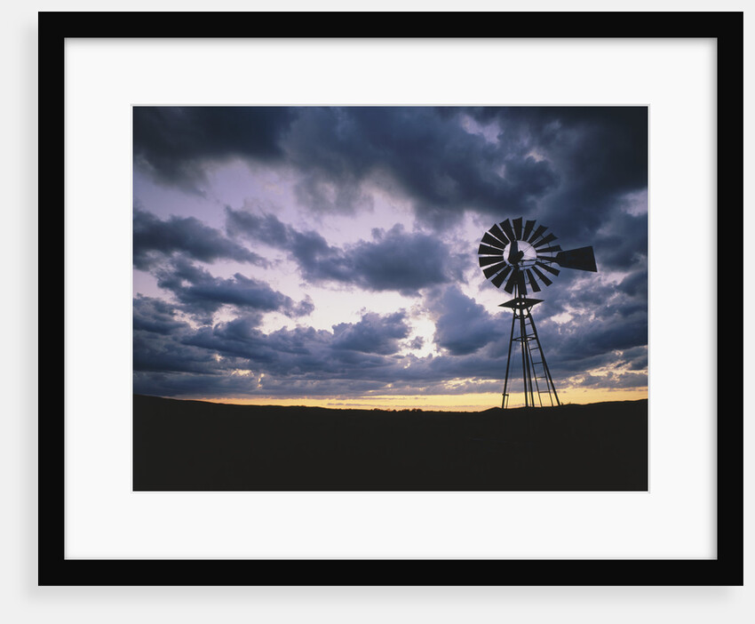 Windmill Silhouette Under Broken Clouds by Anonymous