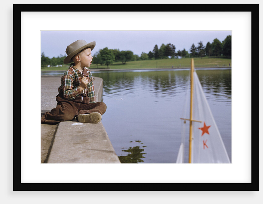 Boy Sitting by Lake in Cowboy Hat by Anonymous