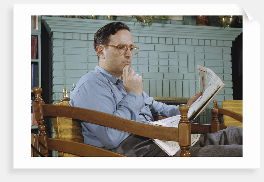 Pensive Man Reading Newspaper in Living Room by Anonymous