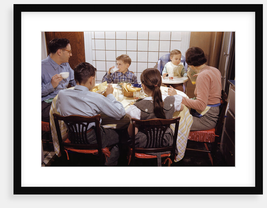 Family Eating Together at Dinner Table by Anonymous