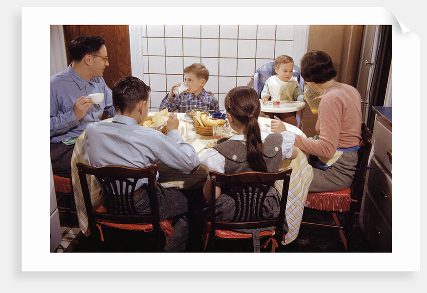 Family Eating Together at Dinner Table by Anonymous