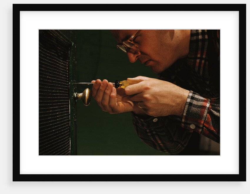 Man Fixing Knob on Screen Door by Anonymous