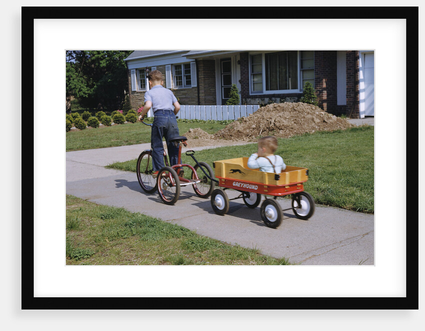 Boy Riding Tricycle and Towing Wagon by Anonymous