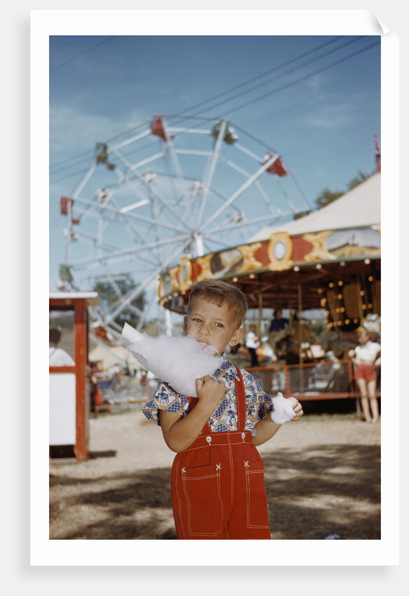 Boy Eating Cotton Candy at Fair by Anonymous