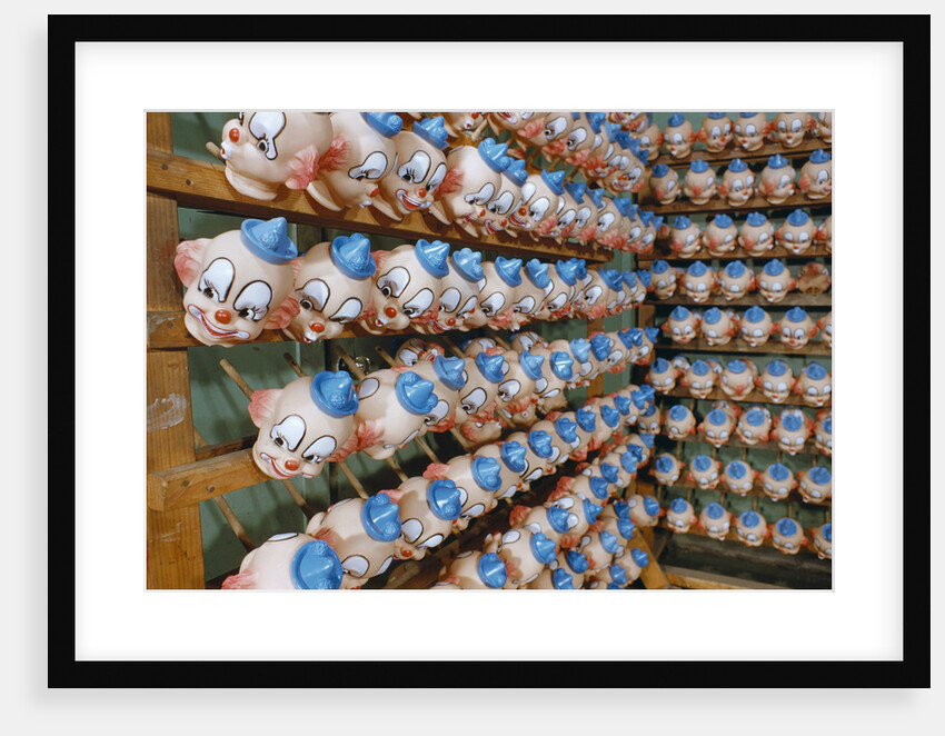 Clown Heads on Rack in Factory by Anonymous