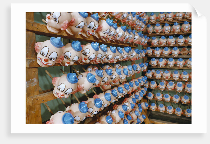 Clown Heads on Rack in Factory by Anonymous