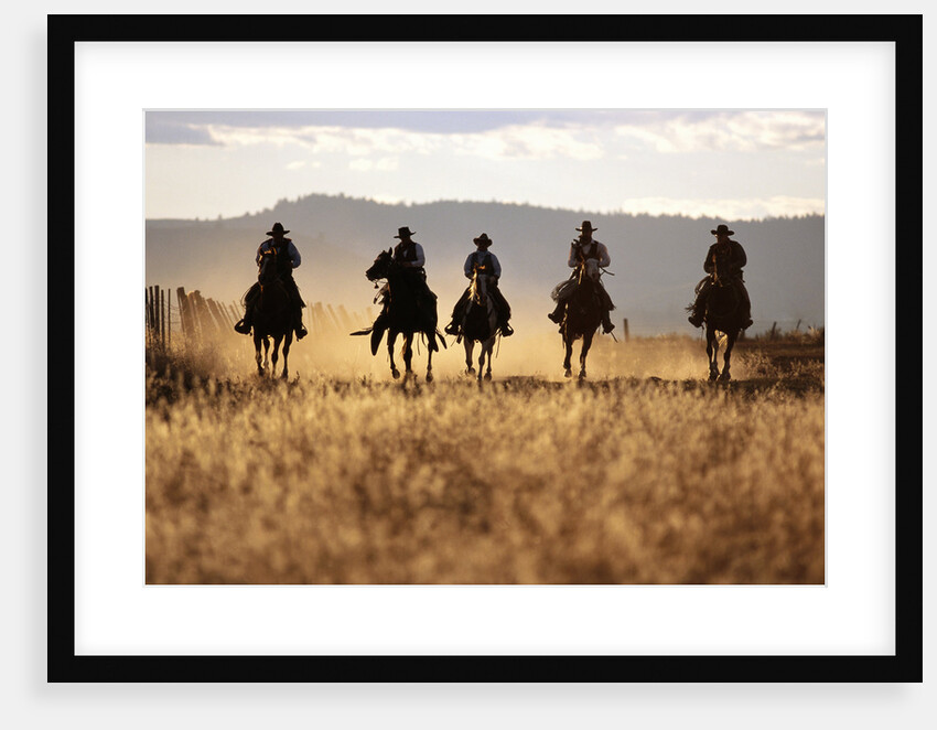 Cowboys Galloping Horses in Field by Anonymous