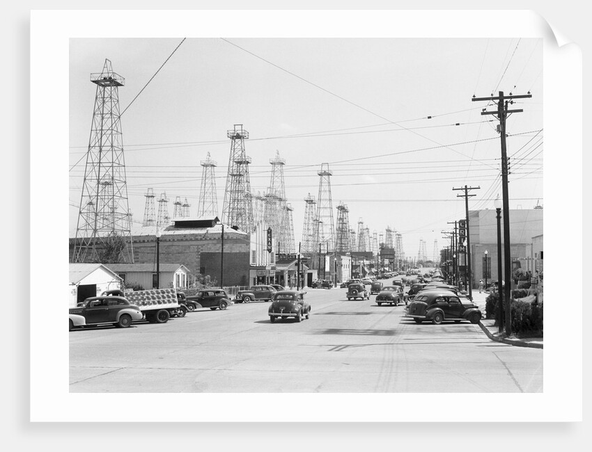 Clusters Of Oil Derricks Along Street by Anonymous