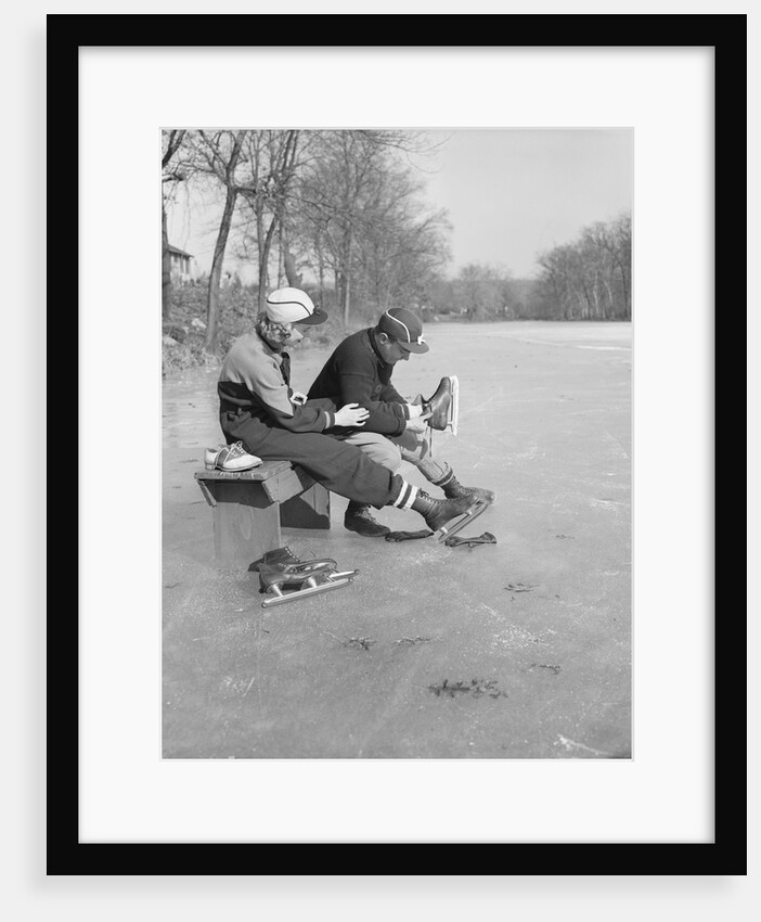 Man Puts Ice Skates On Woman At Rink by Anonymous