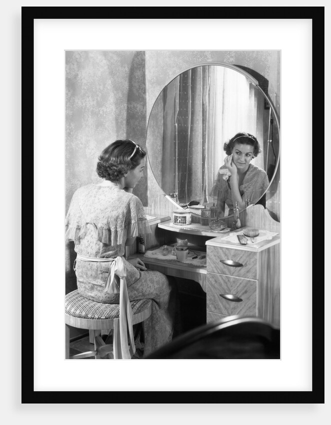 Young Woman Applying Face Cream at Vanity by Anonymous