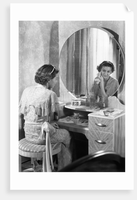 Young Woman Applying Face Cream at Vanity by Anonymous