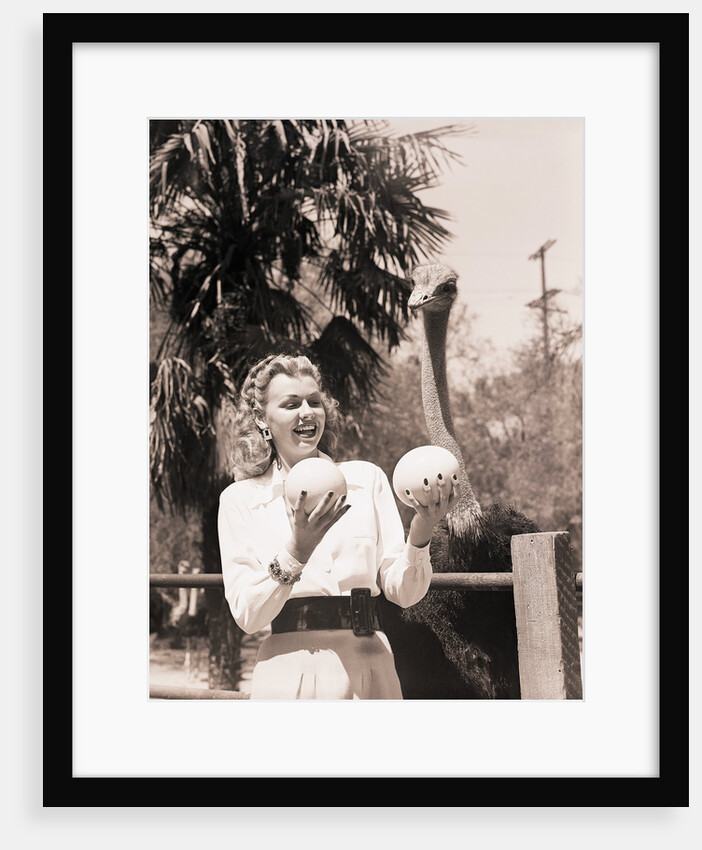 Ostrich Behind Woman Holding Its Eggs by Anonymous
