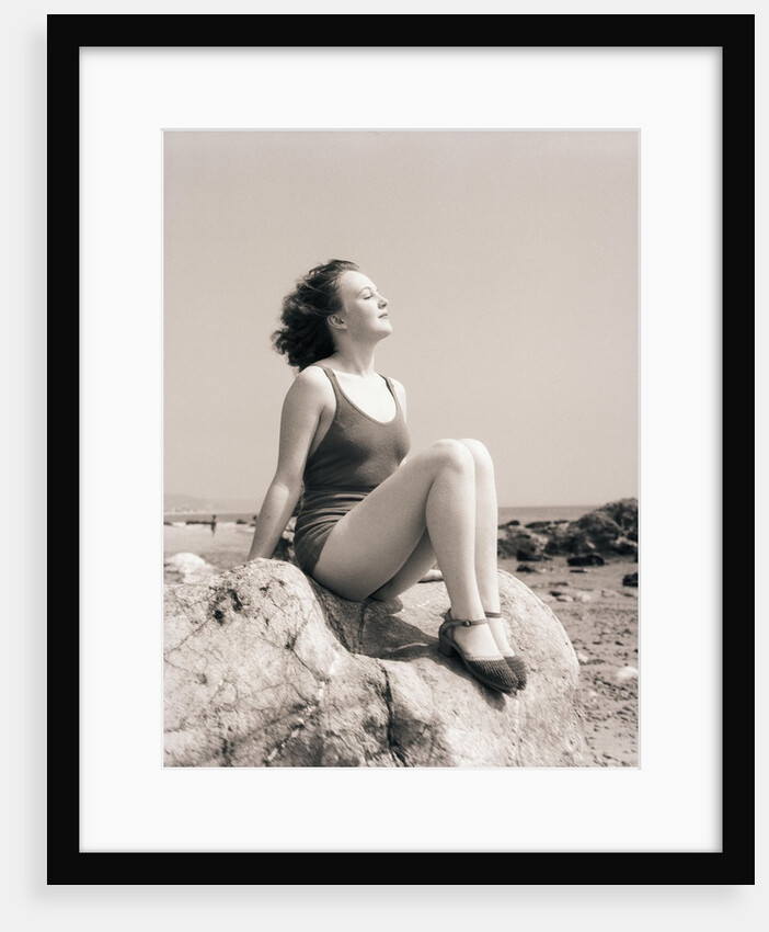 Young Woman Sitting on Beach Rocks by Anonymous