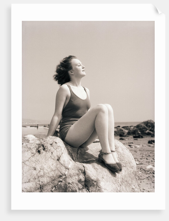 Young Woman Sitting on Beach Rocks by Anonymous