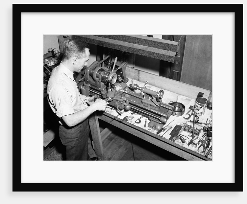 Man Working with Lathe in Basement Workshop by Anonymous