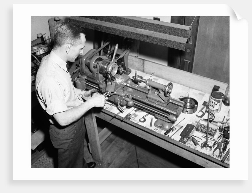 Man Working with Lathe in Basement Workshop by Anonymous