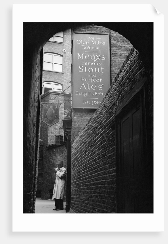 Man Outside Ye Olde Mitre Tavern by Corbis