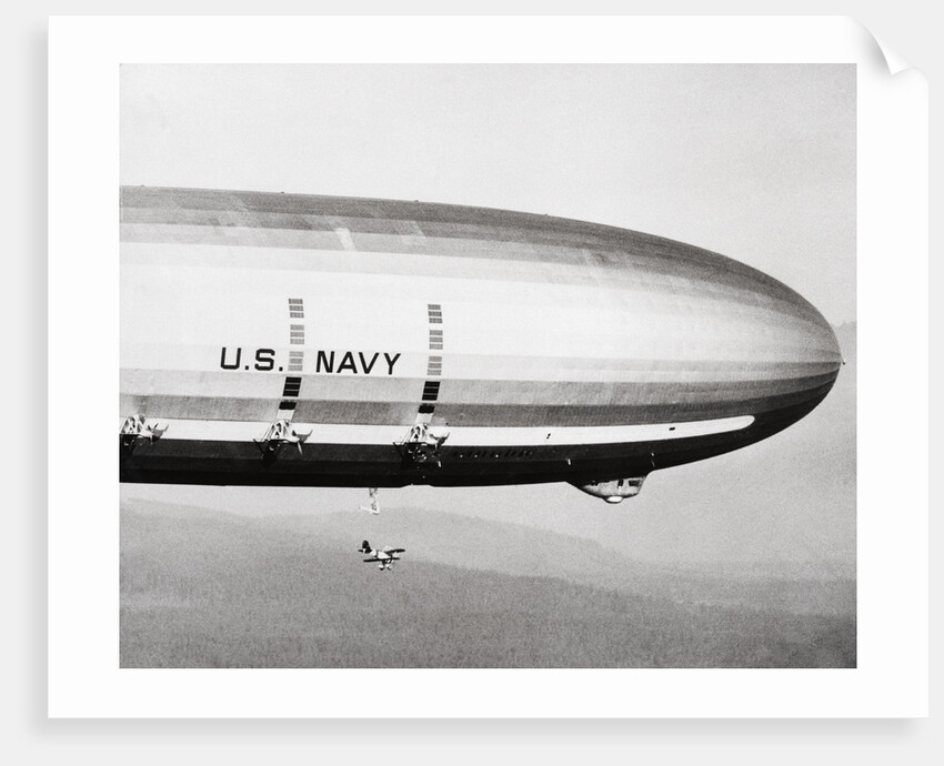 Plane Underneath Huge Dirigible in Flight by Anonymous