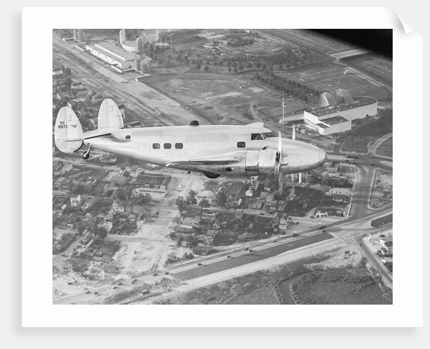 Howard Hughes Lockheed 14 Super Electra over Worlds Fair Site by Anonymous