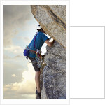 Young man rock climbing up a vertical cliff by Anonymous