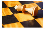King chess piece lying on chessboard by Anonymous
