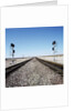 Railroad tracks running through desert setting by Anonymous