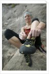 Woman Putting on Rock Climbing Shoes by Anonymous