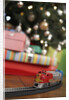 Toy train running beneath Christmas tree by Anonymous