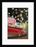 Toy train running beneath Christmas tree by Anonymous