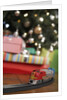 Toy train running beneath Christmas tree by Anonymous