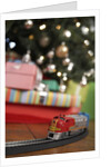Toy train running beneath Christmas tree by Anonymous