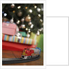 Toy train running beneath Christmas tree by Anonymous
