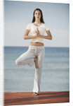 Woman doing yoga by the ocean by Anonymous