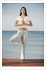 Woman doing yoga by the ocean by Anonymous